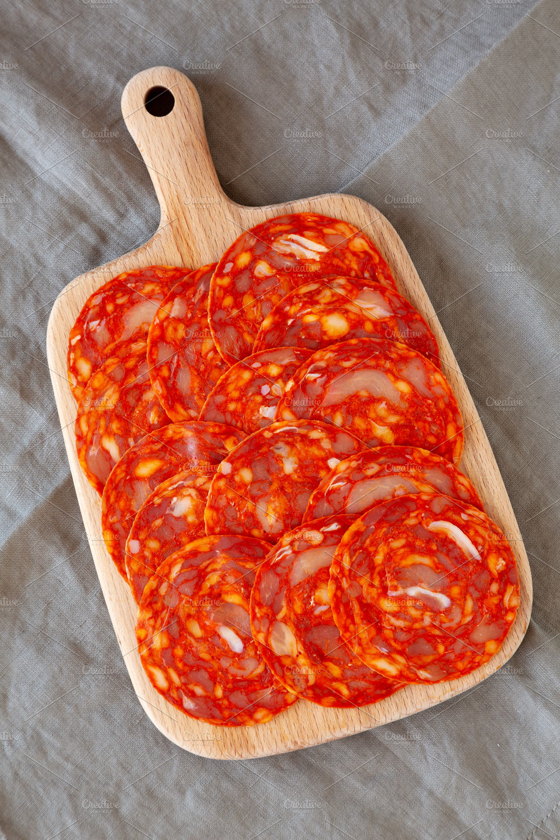 Cold Meat Chorizo Slices on a Wooden Board, top view., a Food & Drink Photo by LiudmylaChuhunova