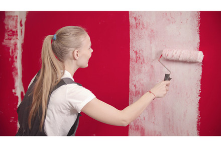 Young woman is painting a red wall, a Person Photo by Barcelona_dreams