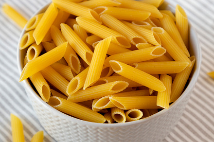 Uncooked Organic Penne Pasta in a Bowl, low angle view., a Food & Drink Photo by LiudmylaChuhunova