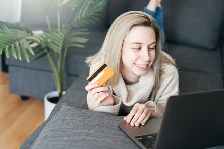 Young woman holding credit card and using laptop computer., a Business Photo by Olena Rudo