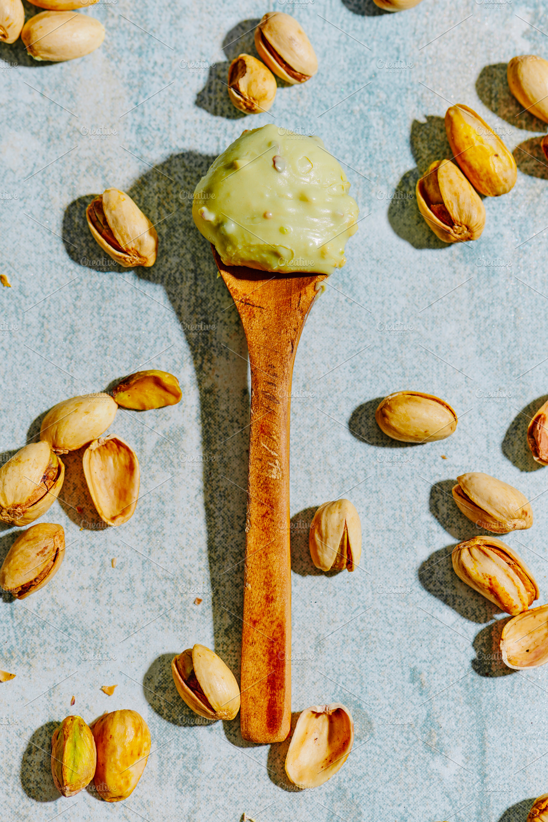 a scoop of pistachio cream on a wooden spoon, a Photo by Nito