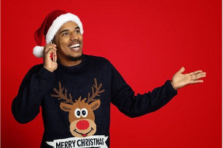 Cheerful black guy in Santa hat, a Person Photo by Prostock-Studio