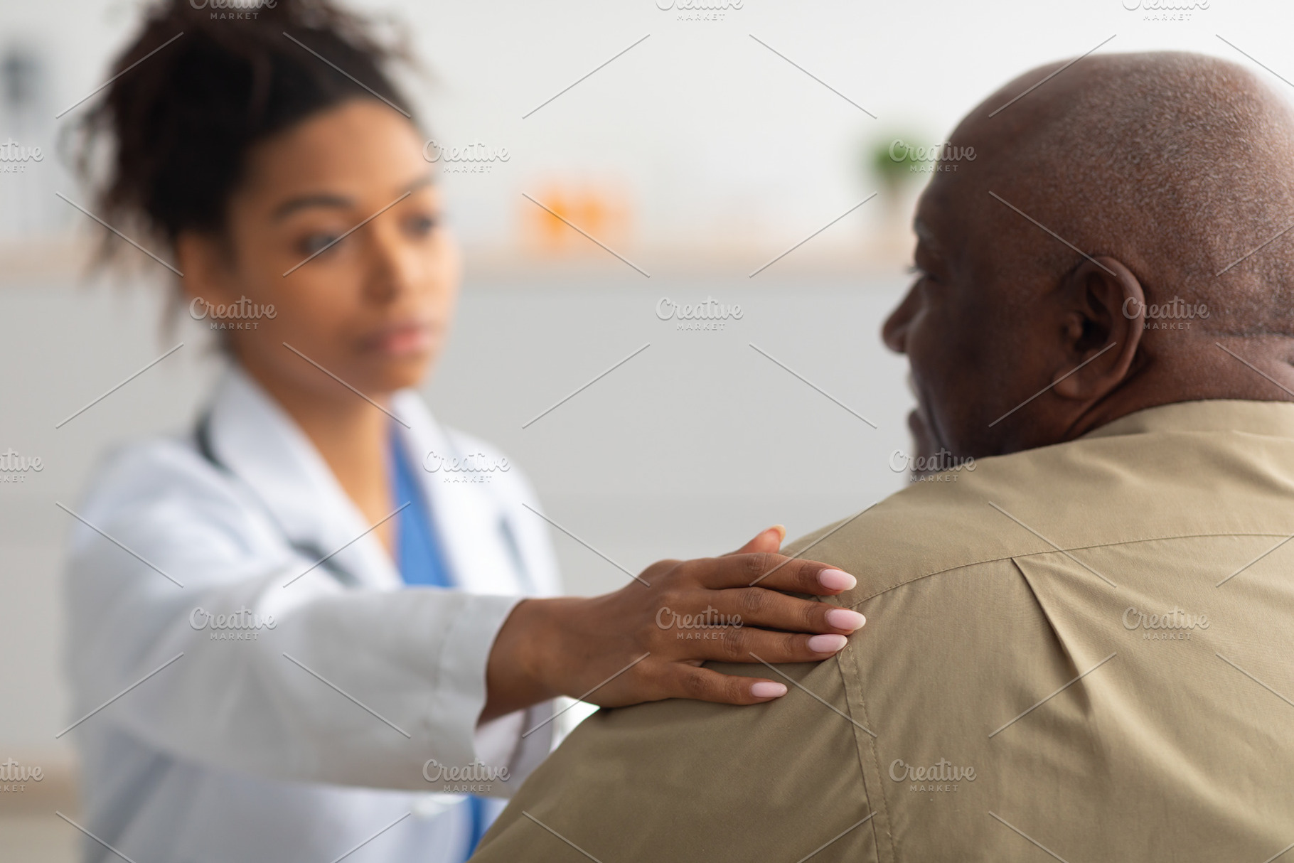 Close up of black female doctor tapping patting patient's shoulder, a Photo by Prostock-Studio