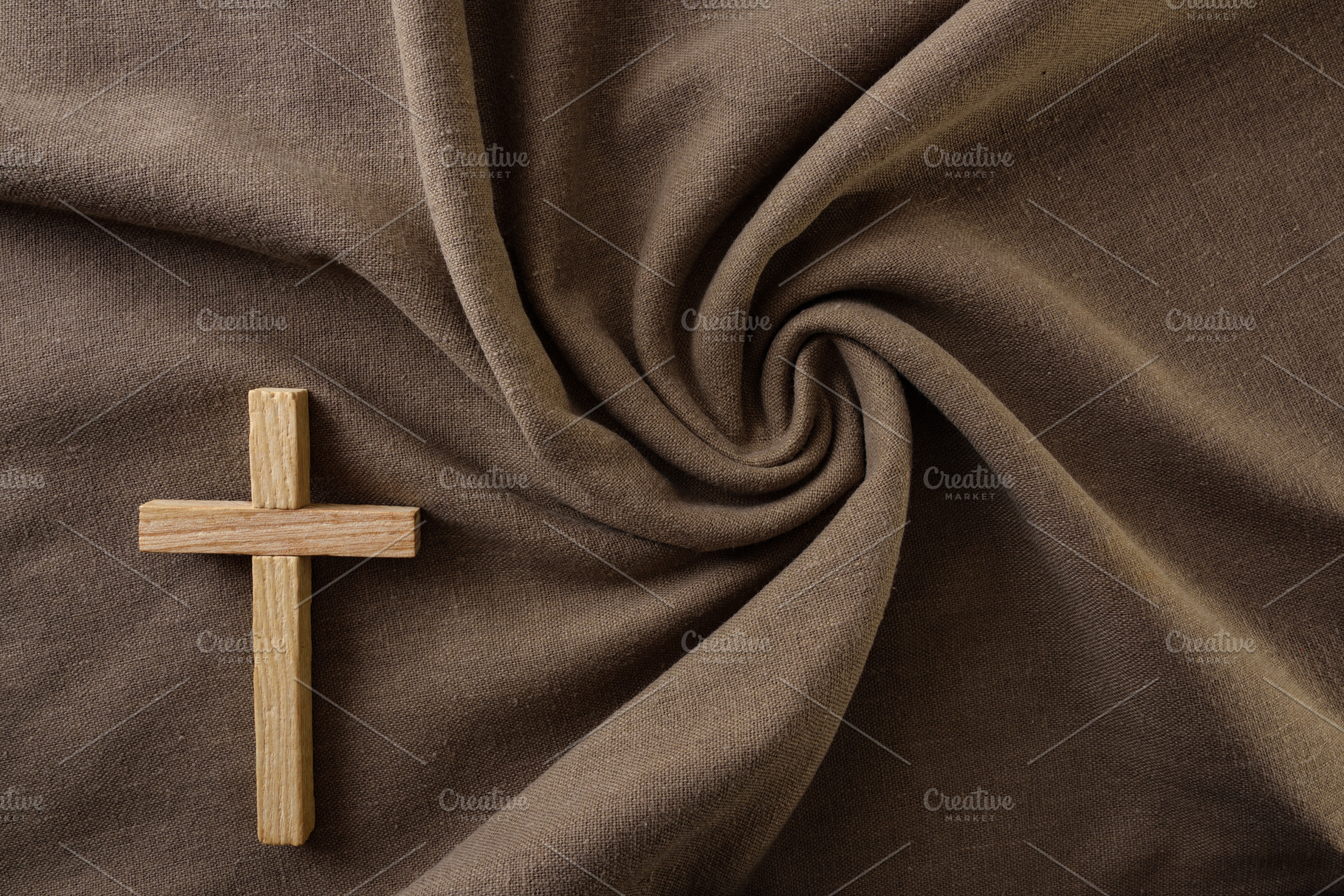 Wooden Cross on Swirled Brown Fabric Background, a Holiday Photo by Davizro's Market