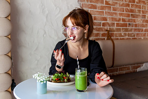 Woman enjoying healthy meal with green smoothie in cozy cafe, a Person Photo by Photostock