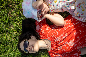 Top view of a mother and daughter lying on green grass, smiling, a Person Photo by Imaginarium
