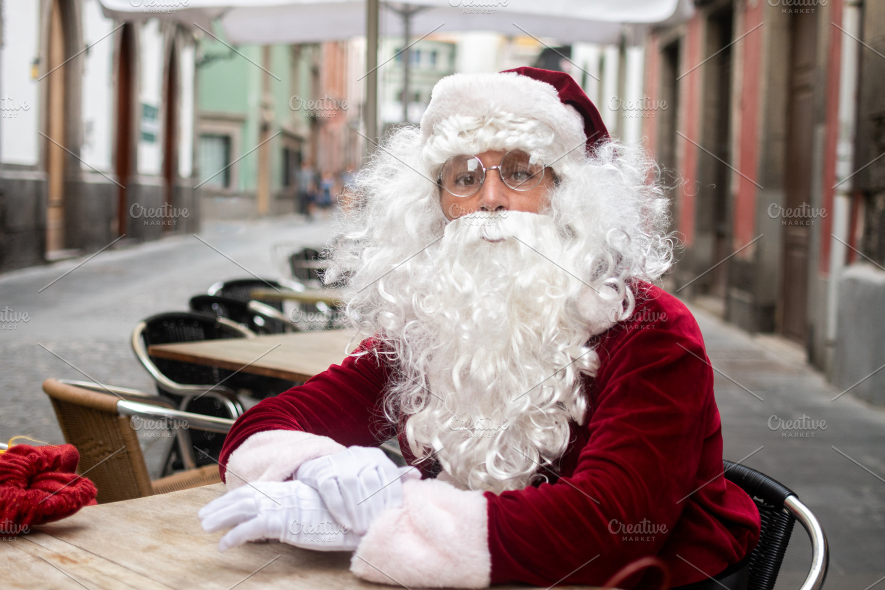 Santa Claus sitting at outdoor cafe terrace in city street, a Photo by etorres69