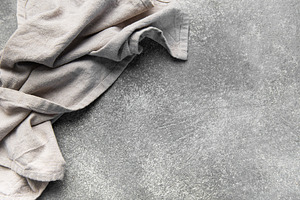 Crumpled linen napkin on rustic gray stone surface, a Food & Drink Photo by Olena Rudo