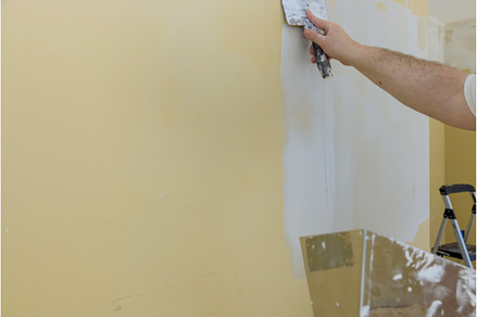 Man plastering the walls with, an Industrial Photo by Ungvar Studio