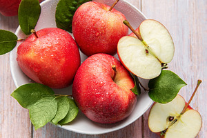 Fresh red apples with water drops and green leaves, a Food & Drink Photo by Olena Rudo