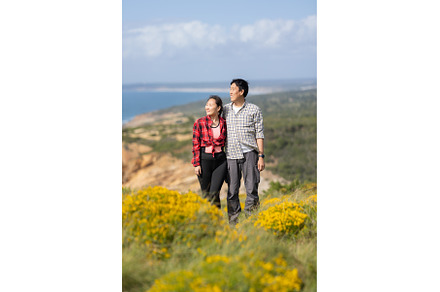 A couple standing on a hillside with