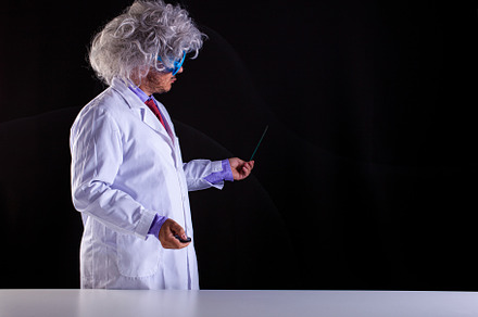 Crazy science teacher in white coat with unkempt hair in funny e, a School & Education Photo by Bepslabor