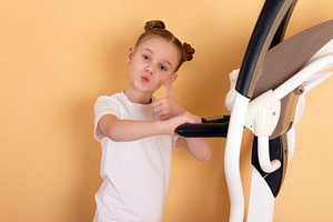 Smiling young girl in white t-shirt giving thumbs up while stand, a Person Photo by Ales Munt