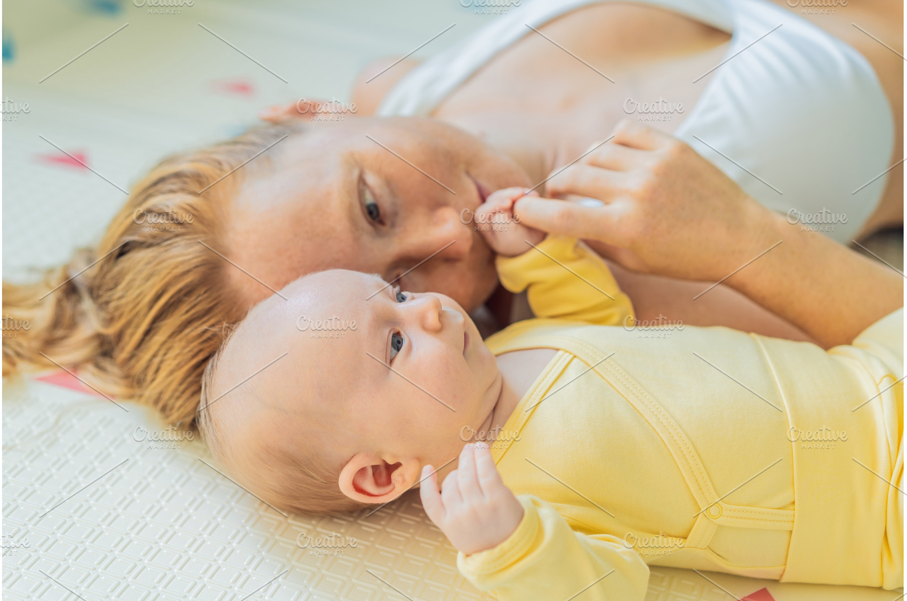 Mother and baby lying on a play mat, a Person Photo by Elizaveta Galitskaya
