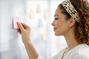 Young Woman Placing Sticky Note, a Photo by rarrarorro