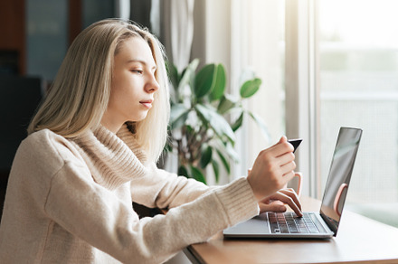 Young woman holding credit card and using laptop computer., a Business Photo by Olena Rudo