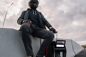 A male rider in protective gear riding an electric wheel. Urban