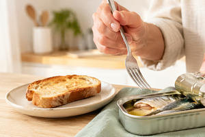 Opening canned sardines with fork in, a Photo by Dvoevnore photos