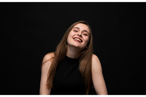 Happy young woman posing on a black, a Person Photo by volodymyrshtun13795