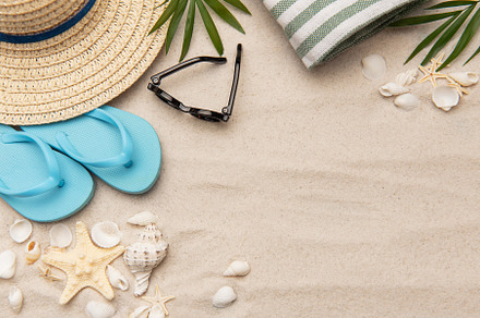 Beach accessories lying on sand creating summer vacation backgro