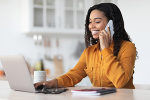Young black business woman working from home, having phone conversation