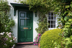 Charming green door of a traditional cottage, surrounded by clim, a Photo by Studio ANNA
