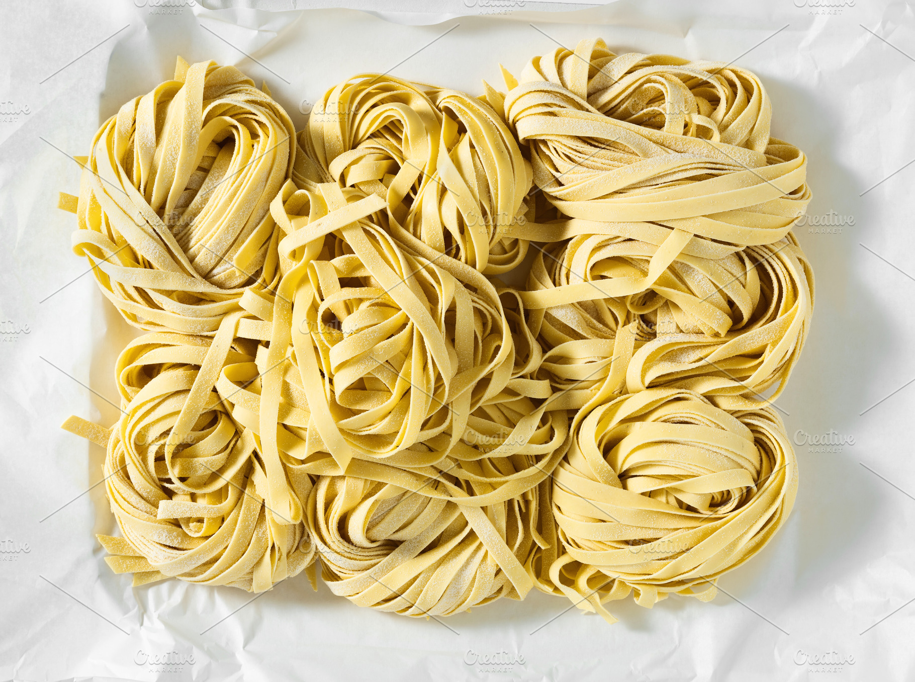 fresh raw Italian tagliatelle pasta, ready for cooking. home mad, a Food & Drink Photo by IriGri