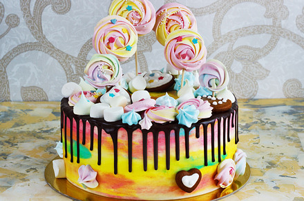 Children's cake rainbow color on a white background with wood meringue