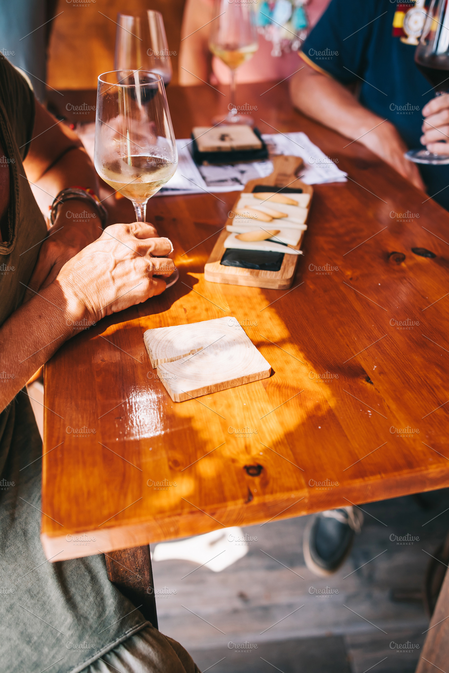 People eat cheese and drink wine in, a Photo by BodiaPhoto
