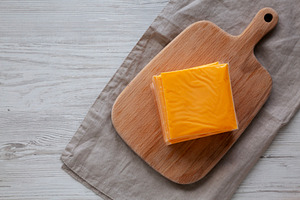 Stack of American Cheese Slices in Wrappers, top view. Copy spac, a Food & Drink Photo by LiudmylaChuhunova