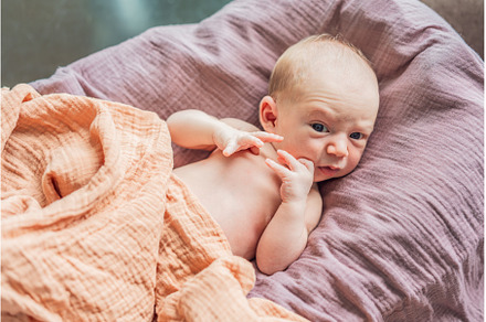 A newborn lies in his cozy cocoon on, a Person Photo by Elizaveta Galitskaya