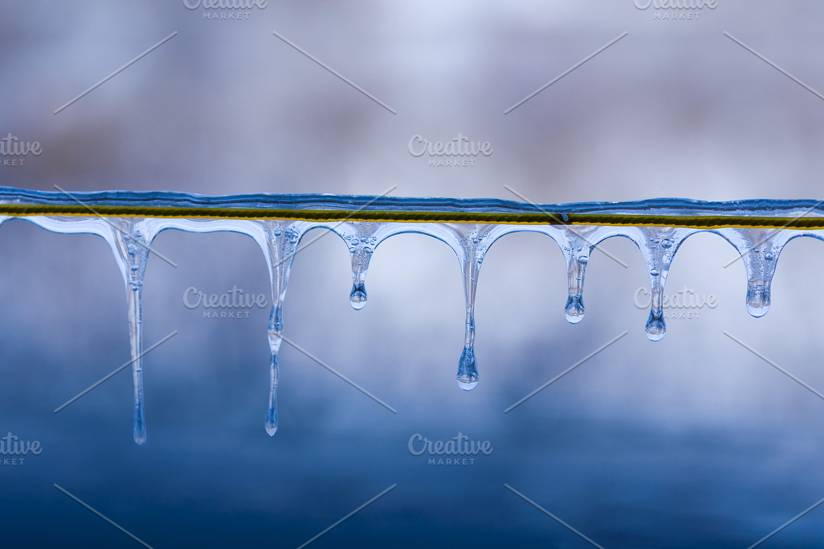 Close-up of clear icicles hanging from a wire against a soft blu, a Background Photo by Ales Munt (Photo 1 of 2)