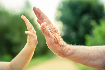 Child and senior man hands give five, a Person Photo by davidpereiras