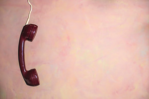 Red phone handset and pink wall containing phone, telephone, and handset