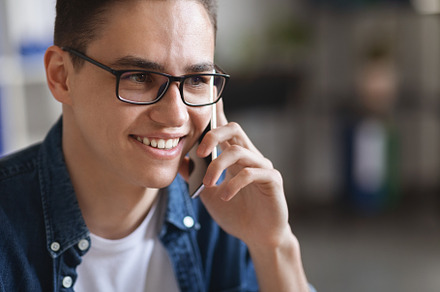Close Up Of Millennial Handsome Man Wearing Eyeglasses Talking On Mobile Phone