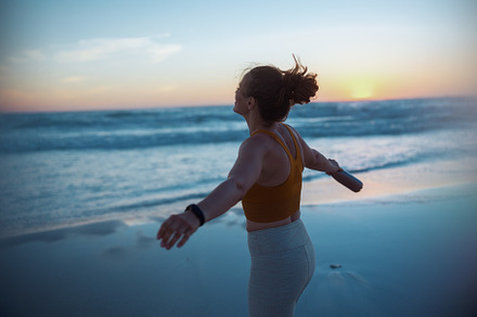relaxed active sports woman rejoicing at beach at sunset, a Sports & Recreation Photo by Alliance Images