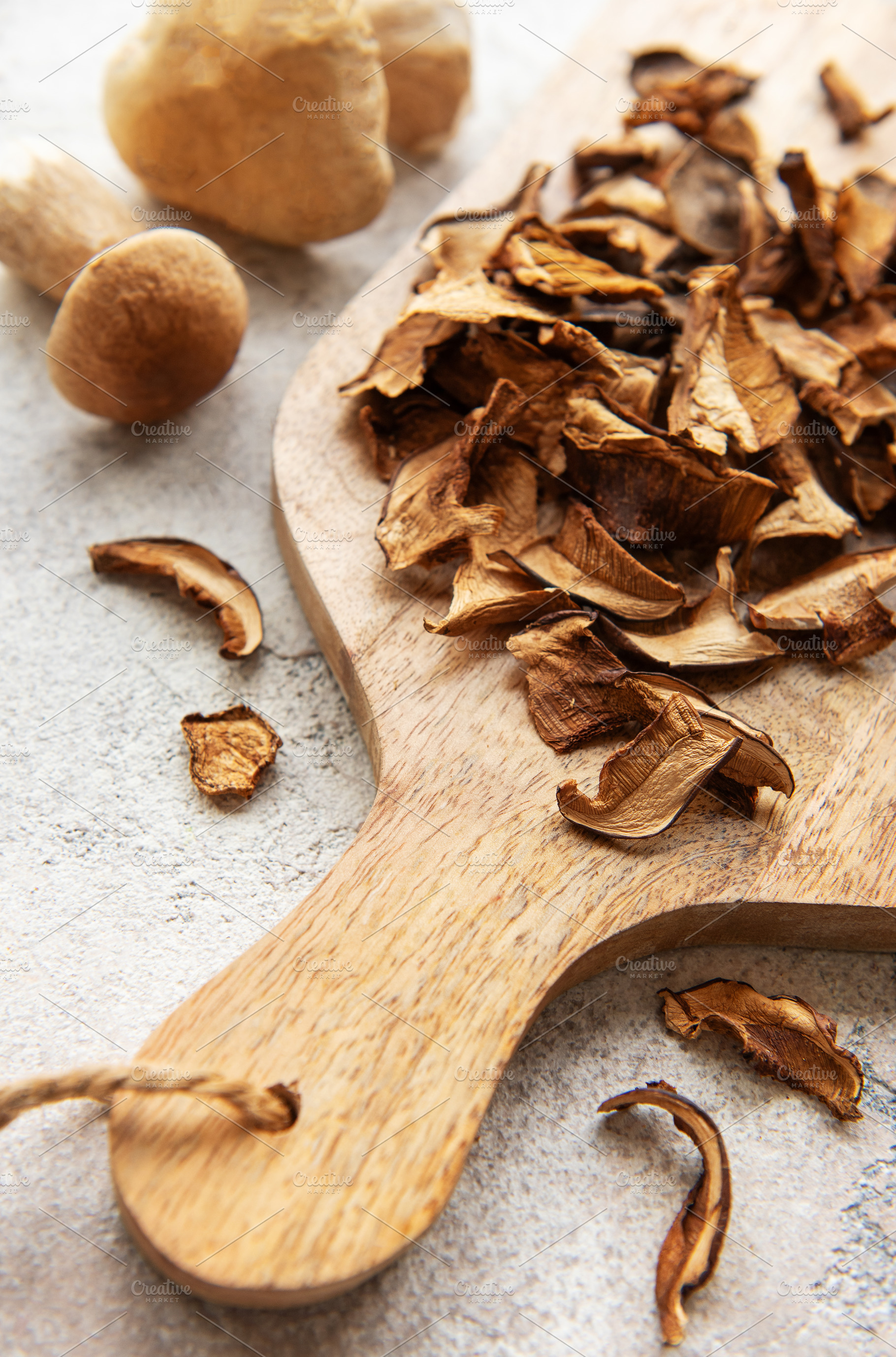 Dried mushrooms on wooden cutting board with fresh mushrooms, a Food & Drink Photo by Olena Rudo