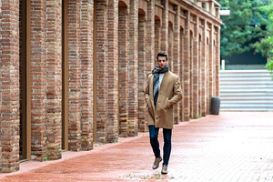 Confident man walking between brick and glass buildings, a Person Photo by RF Images