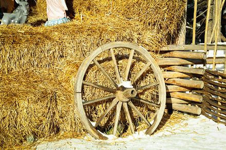 Wooden wheel near straw outdoor in winter season, a Nature Photo by AtlasStudio PRO