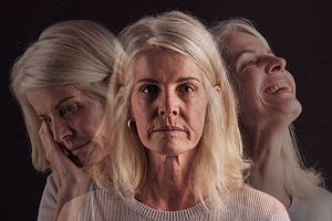 Senior woman, bipolar or mental health for depression, psychology or mood swings. Mature female, depressed or schizophrenia with identity crisis, trauma anxiety or problem with portrait, sad or smile, a Photo by Peopleimages.com