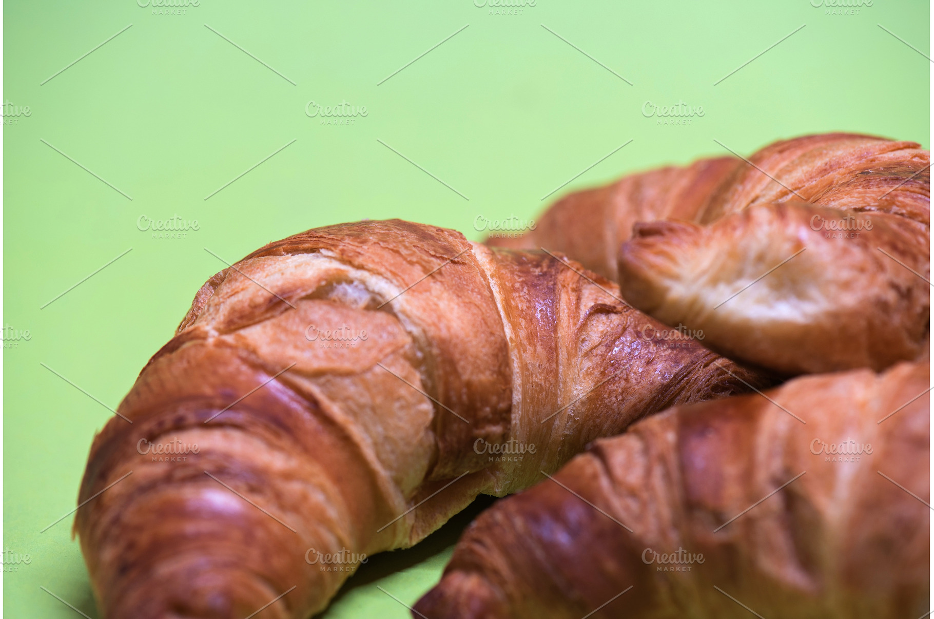 Macro shoot of croissants over green, a Food & Drink Photo by Beautiful things