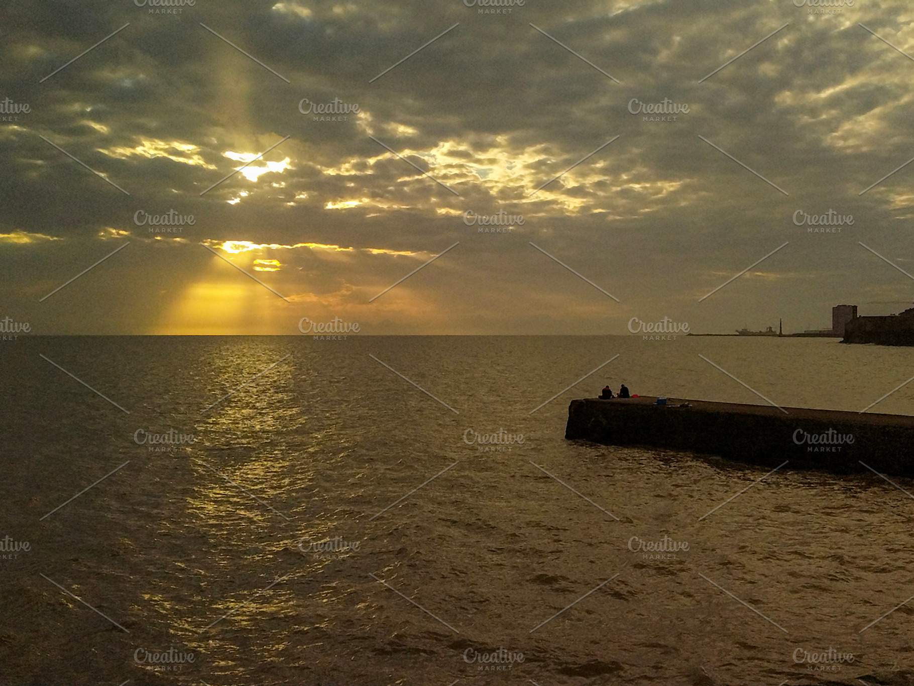 Sunset rays breaking through clouds over the sea, a Nature Photo by DanFLCreativo