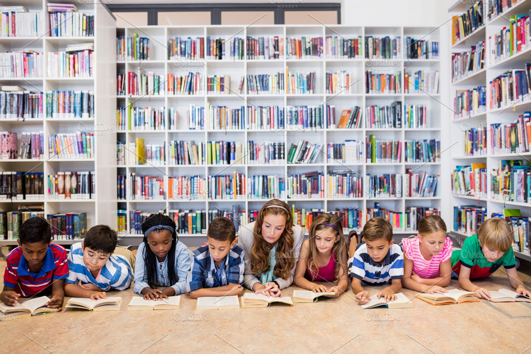 Teacher reading books to her students, a Photo by wavebreak