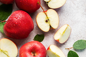 Fresh red apples with green leaves on grey background, a Food & Drink Photo by Olena Rudo