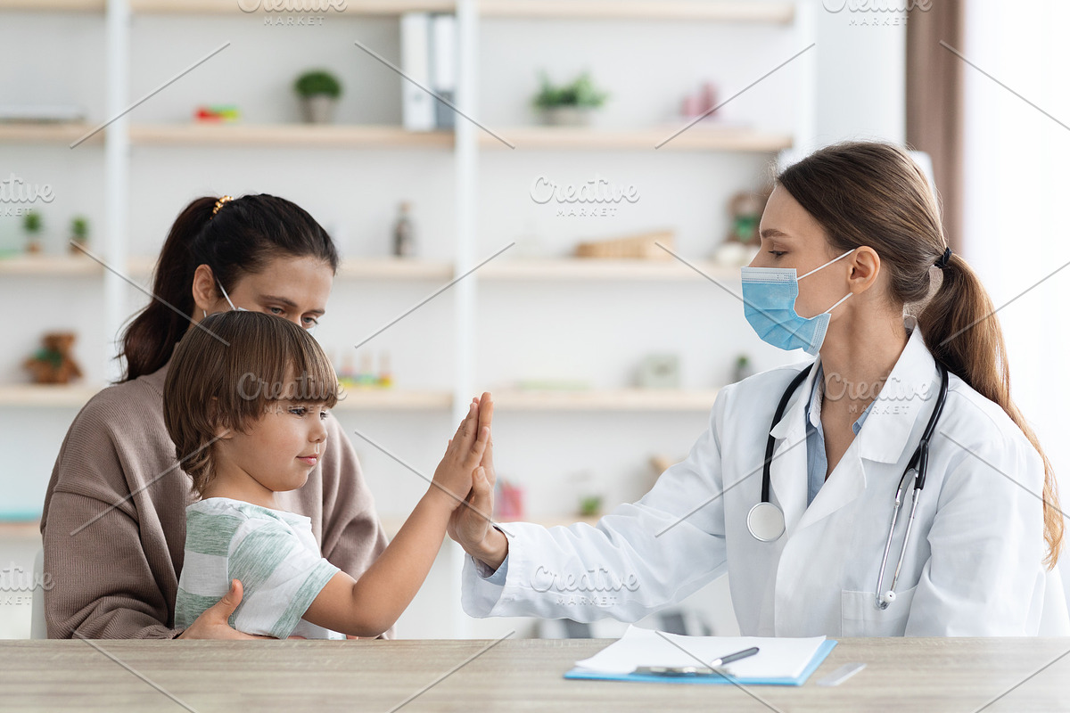 Happy little boy giving high five to professional woman doctor, sitting with mo, a Photo by Prostock-Studio (Photo 1 of 2)