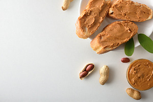 Bread with peanut butter isolated on white table, a Food & Drink Photo by Davizro's Market