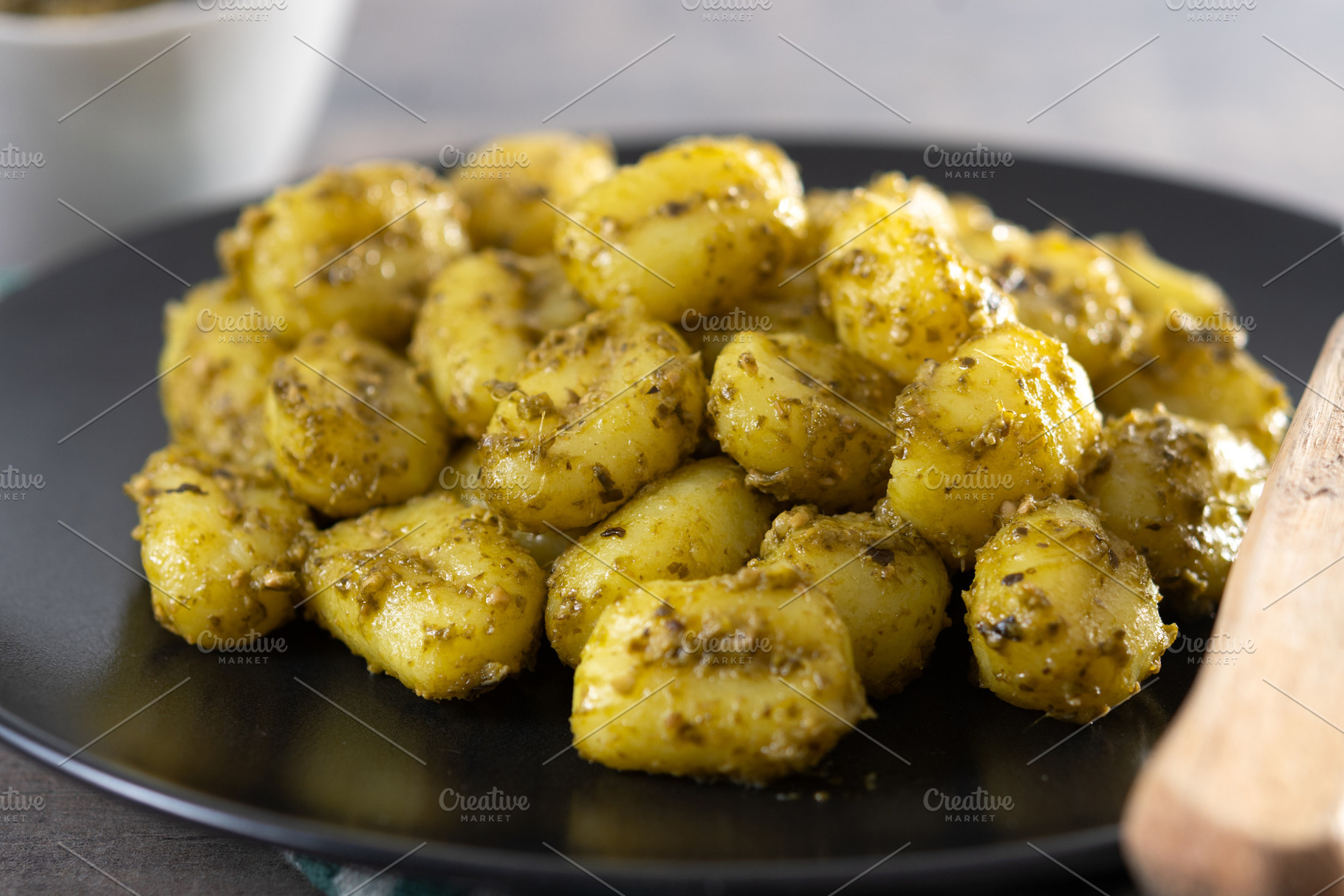 Gnocchi with pesto sauce served on black plate, a Food & Drink Photo by etorres69