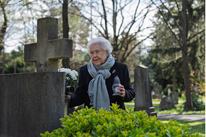Old woman lighting a candle at a, a Holiday Photo by HalfPoint
