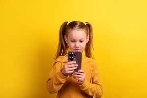 Young girl with pigtails in a mustard sweater holding and lookin, a Person Photo by Ales Munt