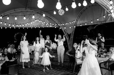 bride in a white dress throws a wedding bouquet